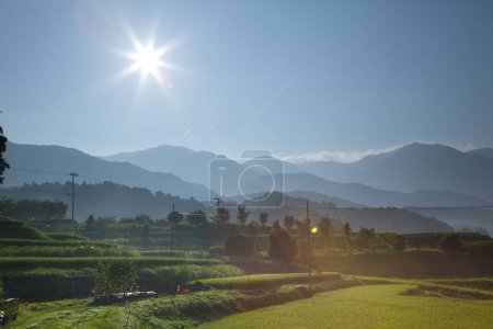 Foto de Hermoso paisaje rural con campo verde y montañas pintorescas en la mañana - Imagen libre de derechos