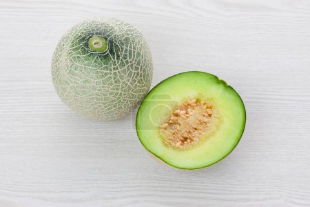 Photo for Close-up view of fresh ripe organic melons on light wooden background - Royalty Free Image