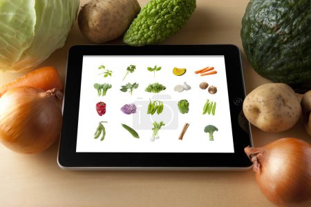 Téléchargez les photos : Vue rapprochée de la tablette moderne avec légumes - en image libre de droit