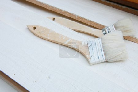 Photo for Paint brushes and wooden boards with white paint - Royalty Free Image