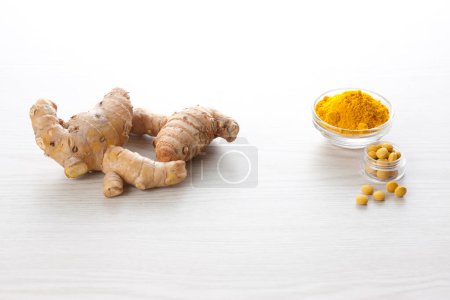 Photo for Turmeric root and powder on the wood background - Royalty Free Image
