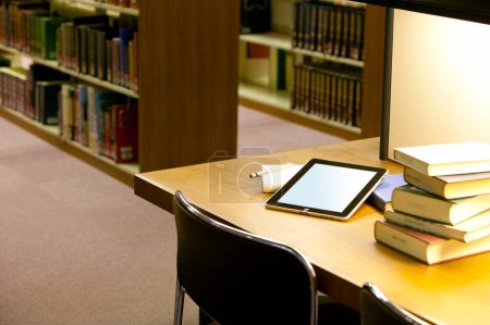 Téléchargez les photos : Vue rapprochée de l'ordinateur tablette dans la bibliothèque - en image libre de droit