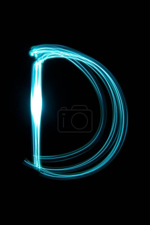 Téléchargez les photos : Lumière peinture lettre D sur le fond sombre - en image libre de droit