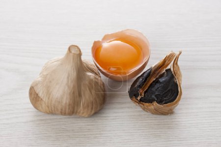 Photo for Black garlic bulbs and egg yolk - Royalty Free Image