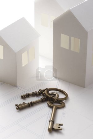 Photo for Close-up view of keys and houses models on white background. real estate concept - Royalty Free Image