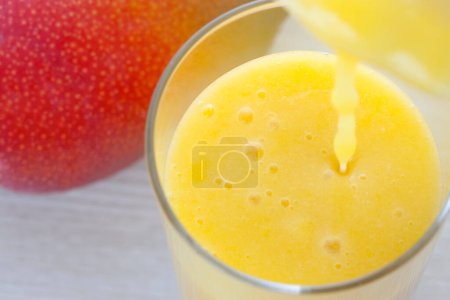 Photo for Glass of mango juice isolated on background - Royalty Free Image