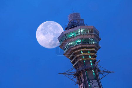 Photo for Full moon and observation deck of Tstenkaku ("Tower Reaching Heaven"), a tower and well-known landmark of Osaka, Japan - Royalty Free Image