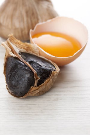 Foto de Bulbos de ajo negro y yema de huevo - Imagen libre de derechos