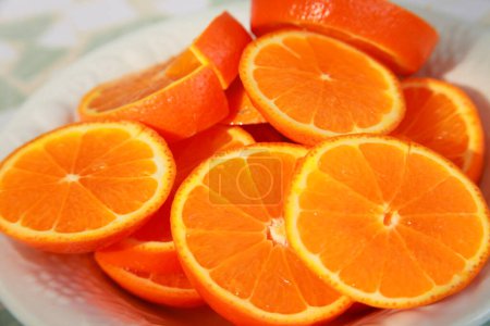 Téléchargez les photos : Frais juteux en tranches d'oranges sur plaque blanche - en image libre de droit