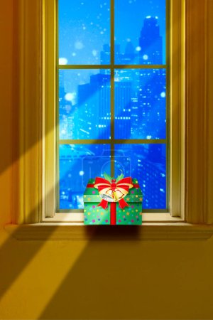 Foto de Regalo de Navidad con cinta roja y campanas en la ventana con fondo de noche de la ciudad - Imagen libre de derechos