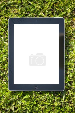 Foto de Tableta digital en fondo de hierba verde. - Imagen libre de derechos