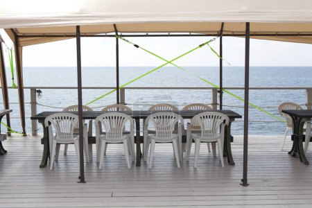 Photo for Tables and chairs on the terrace of an empty restaurant - Royalty Free Image