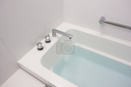 Téléchargez les photos : Baignoire blanche avec eau bleue - en image libre de droit