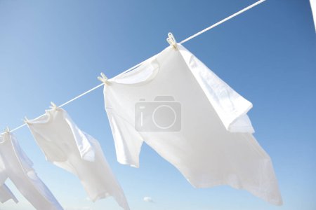 Photo for Clean white clothes drying against blue sky - Royalty Free Image