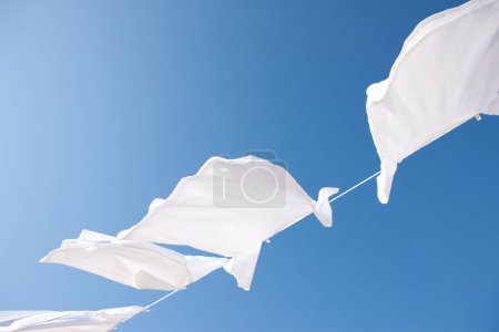 Photo for Clean white clothes drying against blue sky - Royalty Free Image
