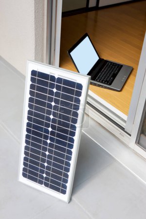 Photo for Solar power panels and laptop on balcony - Royalty Free Image