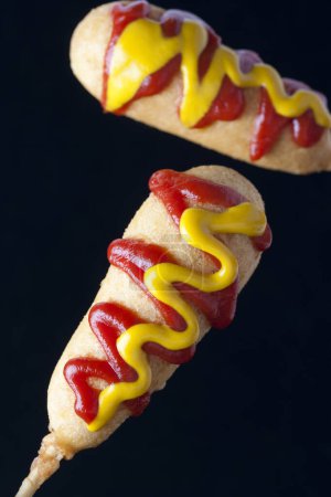 Foto de Primer plano de perritos calientes de maíz con ketchup - Imagen libre de derechos