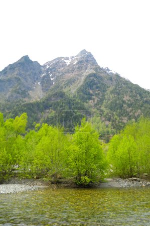 Téléchargez les photos : Une chaîne de montagnes avec une rivière et des arbres - en image libre de droit