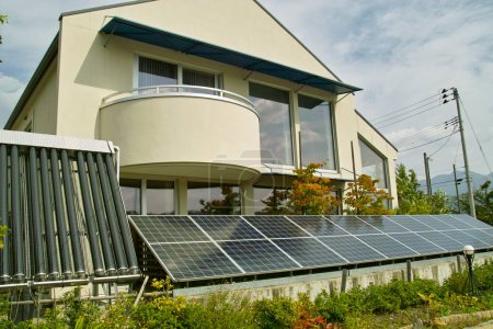 Téléchargez les photos : Panneaux solaires dans le jardin d'une maison de campagne - en image libre de droit