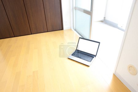 Foto de Portátil con pantalla en blanco en suelo de madera - Imagen libre de derechos