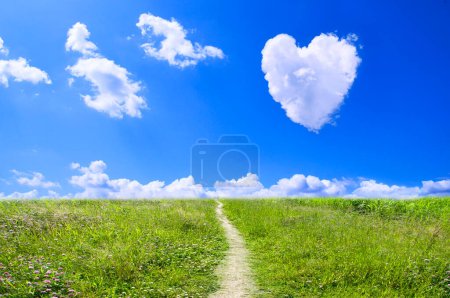 Téléchargez les photos : Nuages en forme de coeur sur ciel bleu sur champ vert - en image libre de droit