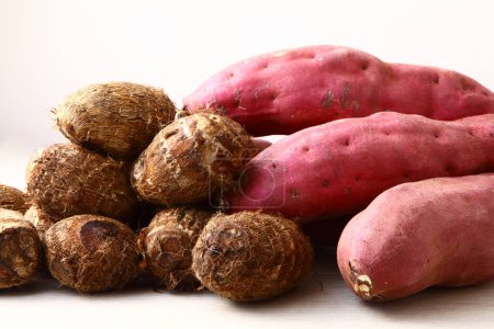 Süßkartoffeln und Satoimo-Kartoffeln (Taro, Taro-Wurzeln) auf weißem Hintergrund