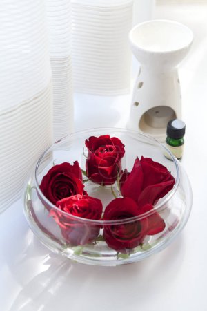 Photo for Red roses in vase, candle and aroma oils on white background. Concept of spa, relaxation, body care. - Royalty Free Image