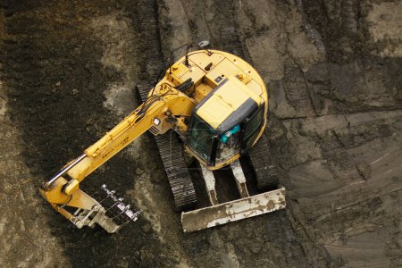 Téléchargez les photos : Excavatrice creuser la terre sur fond de nature - en image libre de droit