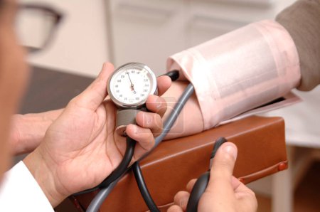 Foto de Médico control de la presión arterial en el paciente en el hospital - Imagen libre de derechos