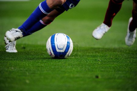 Téléchargez les photos : Jambes de sportifs en vêtements de sport jouant au football sur herbe - en image libre de droit