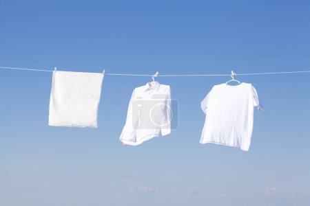 Téléchargez les photos : Vêtements blancs suspendus sur corde à linge, séchage - en image libre de droit