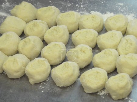 Téléchargez les photos : Boulettes de pâte crue avec de la farine sur la table - en image libre de droit