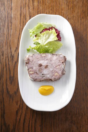Téléchargez les photos : Un plan de cuisine de tranches de viande de Salceson et de feuilles de laitue sur assiette blanche - en image libre de droit