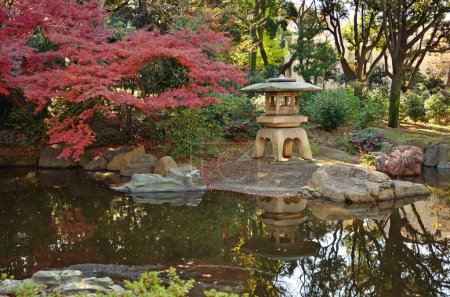Téléchargez les photos : Un étang avec une pagode en pierre et un arbre rouge - en image libre de droit