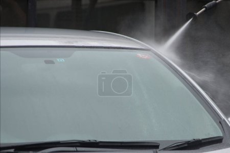 Téléchargez les photos : Une voiture lavée avec un tuyau d'eau haute pression - en image libre de droit