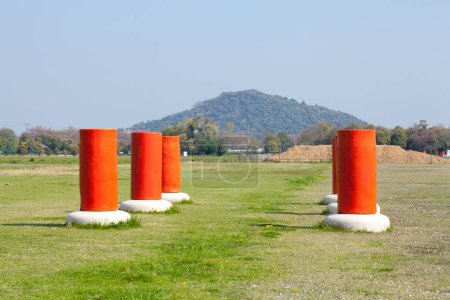 Téléchargez les photos : Un champ avec des pôles orange et une montagne en arrière-plan - en image libre de droit