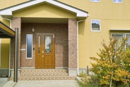 Téléchargez les photos : Une maison avec une porte brune - en image libre de droit