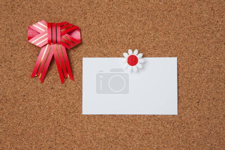 Téléchargez les photos : Un papier à lettres épinglé sur une planche de liège avec un ruban rouge - en image libre de droit