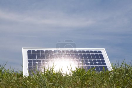 Foto de Panel solar sobre hierba verde sobre fondo azul cielo. fuente de energía alternativa - Imagen libre de derechos