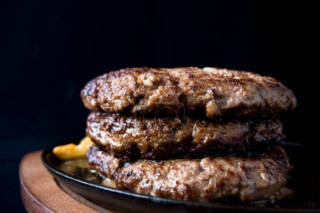 Foto de Sabrosas hamburguesas de carne con papas fritas en el fondo - Imagen libre de derechos