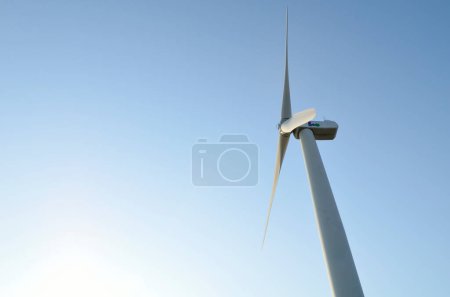 Foto de Molino de viento para la producción de energía eléctrica con fondo azul cielo - Imagen libre de derechos