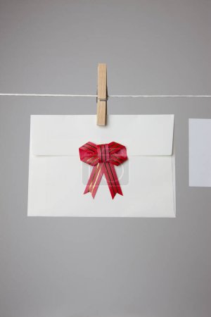 Foto de Tarjeta blanca en blanco y sobre colgando en la cuerda con clavijas de ropa, espacio de copia. - Imagen libre de derechos