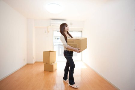Photo for Asian woman moving in new apartment - Royalty Free Image
