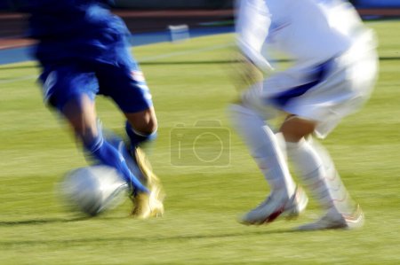 Foto de Piernas de futbolistas en ropa deportiva jugando con pelota sobre hierba - Imagen libre de derechos