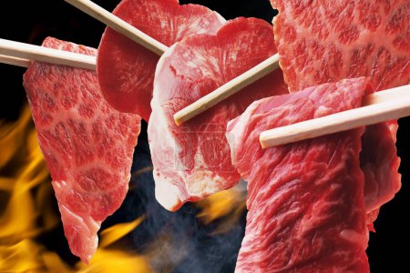 Foto de Vista de cerca de palillos con carne de res en rodajas para barbacoa o yakiniku estilo japonés - Imagen libre de derechos