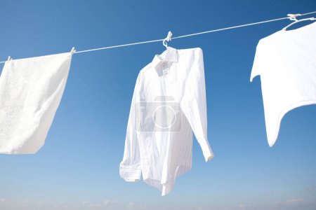 Photo for White clothes hanging on clothesline, drying - Royalty Free Image