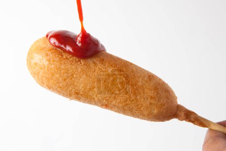 Foto de Primer plano de perrito caliente de maíz con ketchup - Imagen libre de derechos