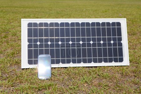 Téléchargez les photos : Panneau solaire smartphone sur herbe verte - en image libre de droit