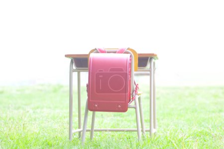 Téléchargez les photos : Table et chaise avec sac d'école dans la forêt - en image libre de droit