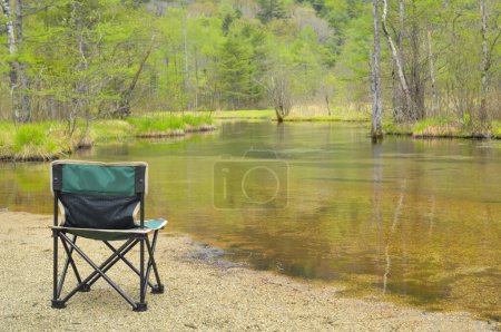 Téléchargez les photos : Chaise près de rivière en forêt verte - en image libre de droit
